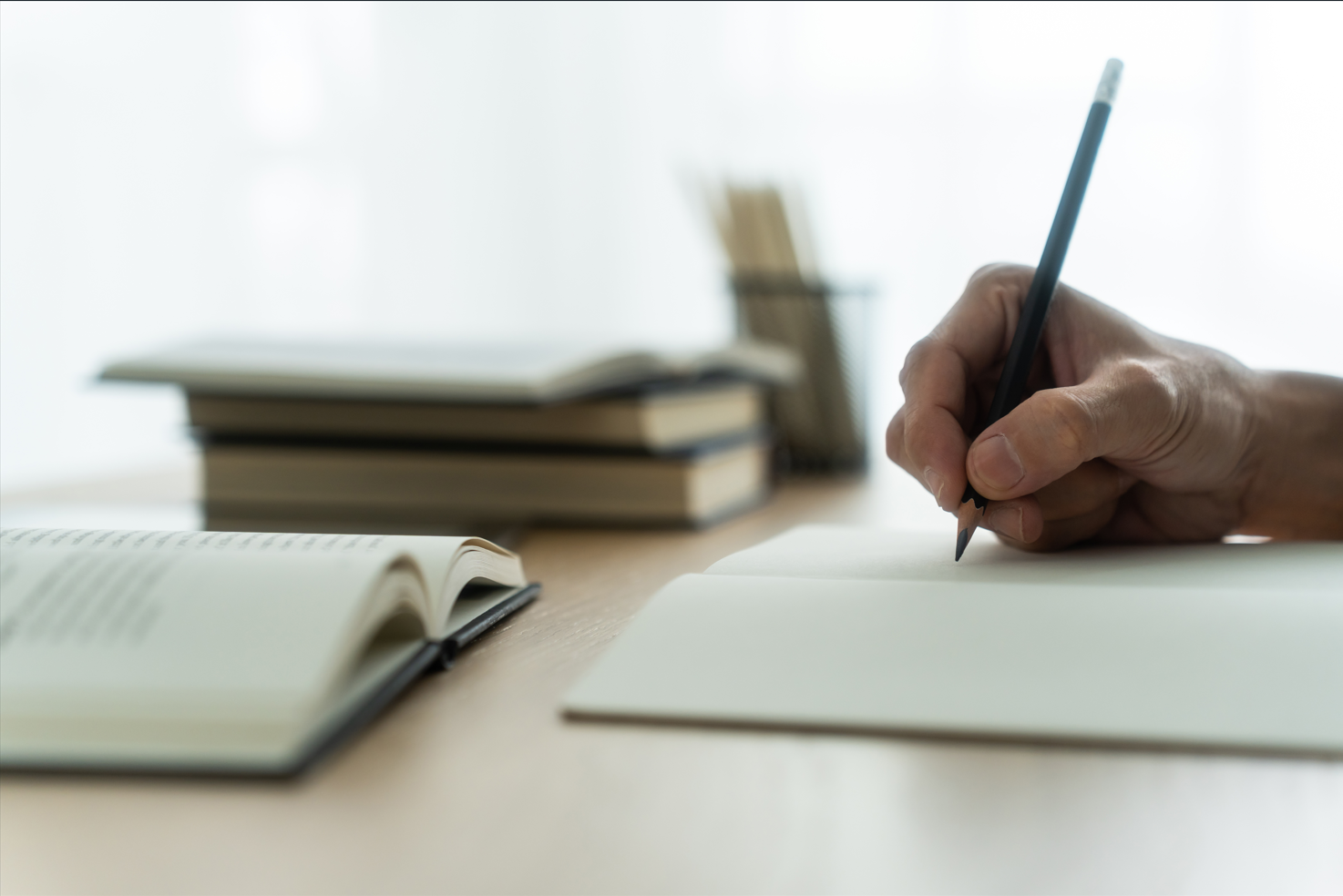 hand holding pen writing on paper